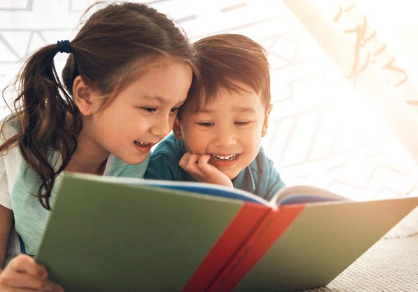 Children happily reading a book together.